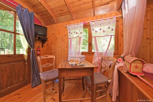 une salle à manger avec une table et des chaises dans une cabine dans l'établissement Roulotte La Verdine, à Dury
