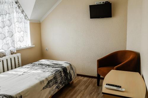 a bedroom with a bed and a chair and a television at Hotel Konus in Făleşti