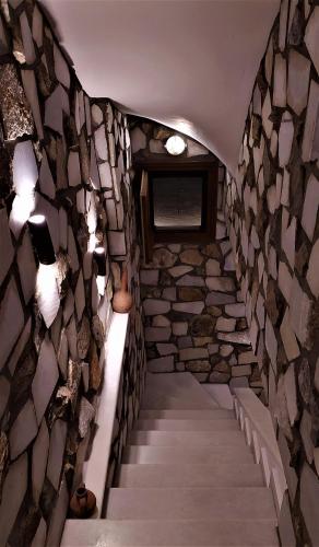 a hallway of a stone wall with a staircase at Pasas Castle - Unique Luxury Apartments in Naxos Chora