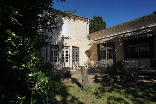 a house with a patio and chairs in the yard at Auberge de Jeunesse HI Arles in Arles