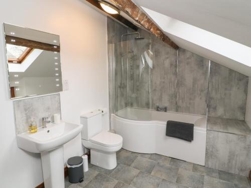 a bathroom with a sink and a toilet and a bath tub at Fryston Cottage in Keswick