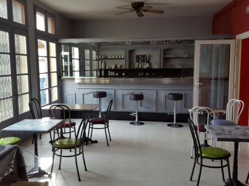 アルルにあるAuberge de Jeunesse HI Arlesのテーブルと椅子、バーが備わる客室です。