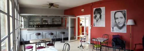 uma cozinha com paredes vermelhas e bancos num quarto em Auberge de Jeunesse HI Arles em Arles