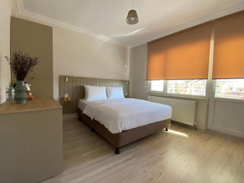 a bedroom with a bed and two windows at Well Hotel Edirne in Edirne