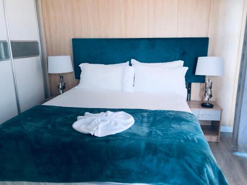 a bedroom with a bed with a white robe on it at Gabz Airport Inn in Gaborone