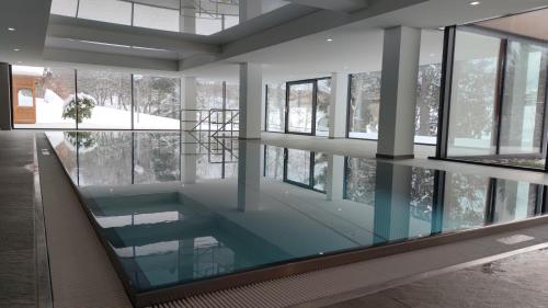 a pool in the middle of a building with windows at Studio 20qm mit Balkon und Innenpool - 22030 in Schluchsee