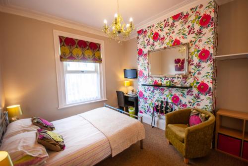 a bedroom with a bed and a mirror and a chair at The Ryedale in Shanklin