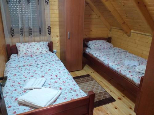 two beds in a room with wooden floors at Mountain house Catherine in Žabljak