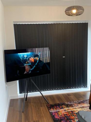 a flat screen tv on a stand in front of a window at Lakeside 2 BED LUXURY APARTMENT No PARTIES No EVENTS Early Check-in Late Check- Out Allowed in West Thurrock