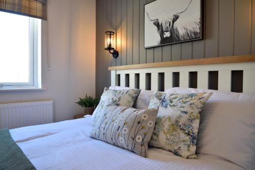 a bed with pillows and a picture of a deer on the wall at The Swift in Whitchurch