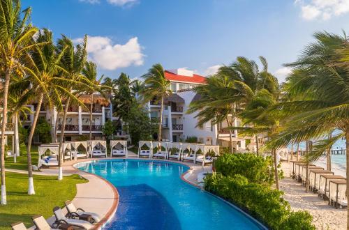 a view of a resort with a pool and palm trees at Desire Pearl Riviera Maya Resort All Inclusive - Couples Only in Puerto Morelos