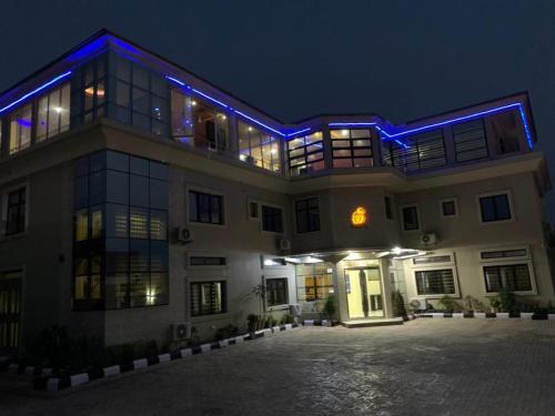 um grande edifício com luzes azuis à noite em TD RESIDENCE INN em Ijebu Ode