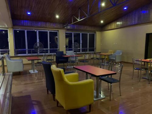 uma sala de jantar com mesas, cadeiras e janelas em TD RESIDENCE INN em Ijebu Ode