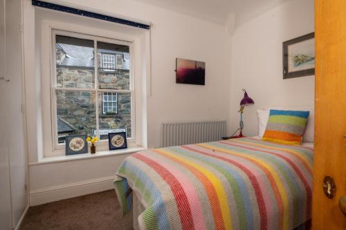 a bedroom with a bed and a window at Cottage in heart of Dolgellau with parking in Dolgellau