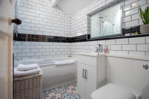 a white bathroom with a tub and a sink at Cottage in heart of Dolgellau with parking in Dolgellau