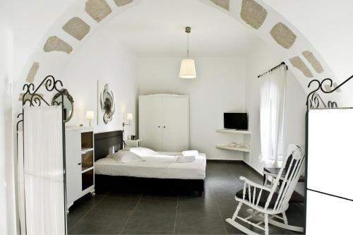 a white bedroom with a bed and a chair at Sunset Villa in Plaka Milou