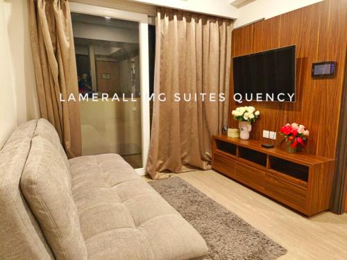 een woonkamer met een bank en een flatscreen-tv bij Lamerall MG Suites Quency in Semarang