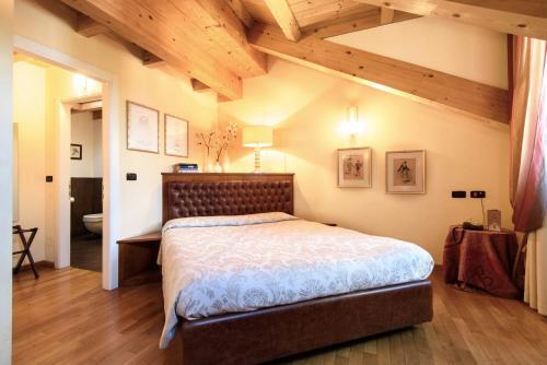 モンツァにあるLocanda San Paoloの木製の天井が特徴のベッドルーム1室(大型ベッド1台付)