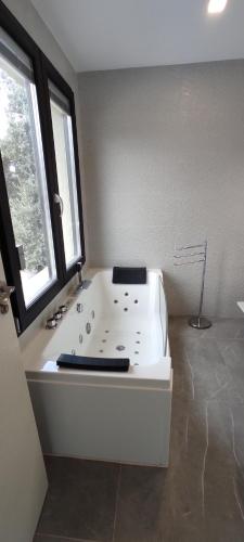 a white bath tub in a room with a window at Las vistas del valle in Hontoba