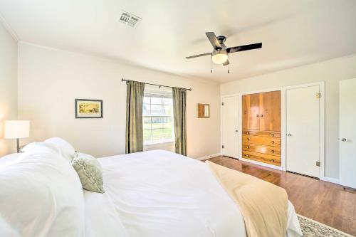 a white bedroom with a bed and a ceiling fan at Lake Eufaula Retreat with Fire Pit, Near Main St! in Eufaula