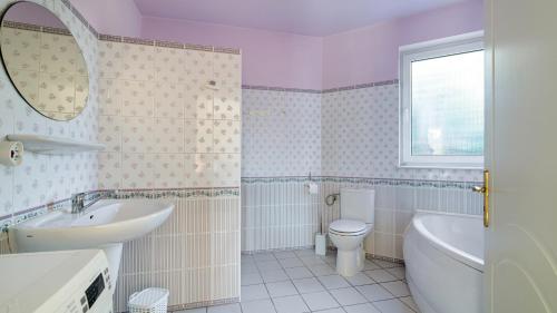 uma casa de banho com um lavatório, um WC e um espelho. em Tosca em Sławoszynko