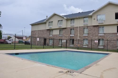 a swimming pool in front of a building at Heritage Inn in Beaumont