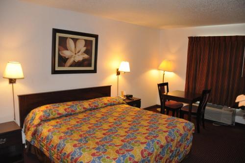 a hotel room with a bed and a desk at Heritage Inn in Beaumont