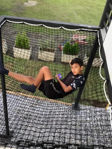 a young boy laying in a batting cage at GatoPardo in Montenegro