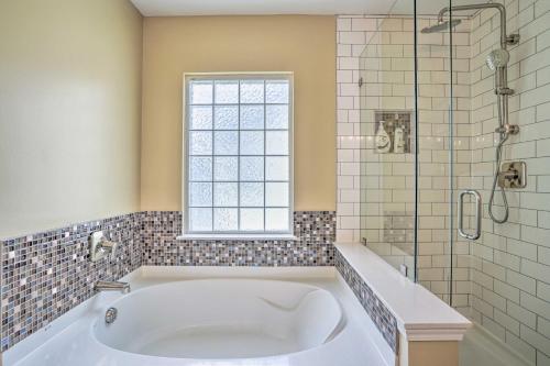a white bath tub in a bathroom with a window at Summerville Family Home about 20 Mi to Charleston in Summerville
