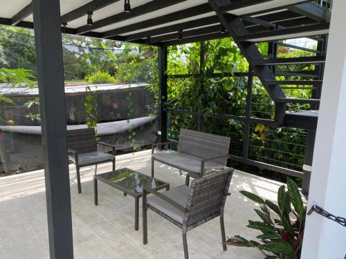 a patio with four chairs and a table and a bench at GatoPardo in Montenegro
