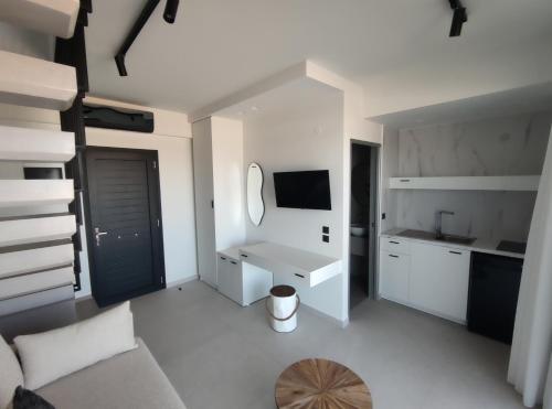 a white living room with a couch and a mirror at Onar in Sarti in Sarti