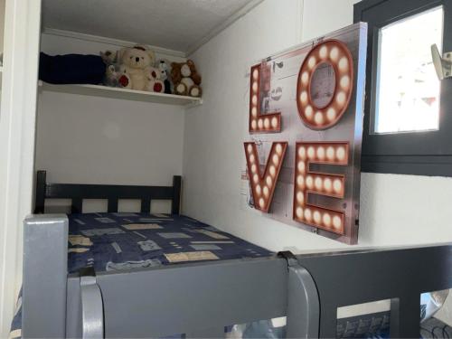 une petite chambre avec un lit et un panneau qui dit amour dans l'établissement Studio Cap Agde, au Cap d'Agde
