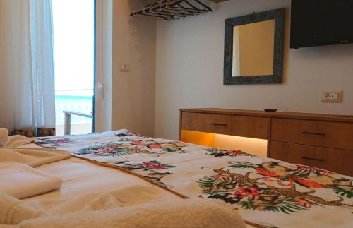 a bedroom with a bed with a dresser and a mirror at En Plo Studios & Apartments in Plakias
