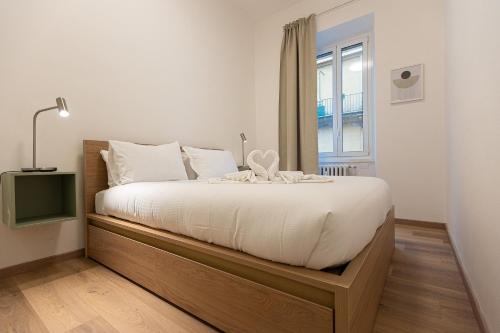a bedroom with a bed with a wooden frame and a window at Matilde Modern apartment-Rental in Rome in Rome