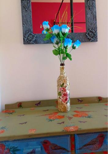 a vase with flowers sitting on a table with a mirror at En Plo Studios & Apartments in Plakias