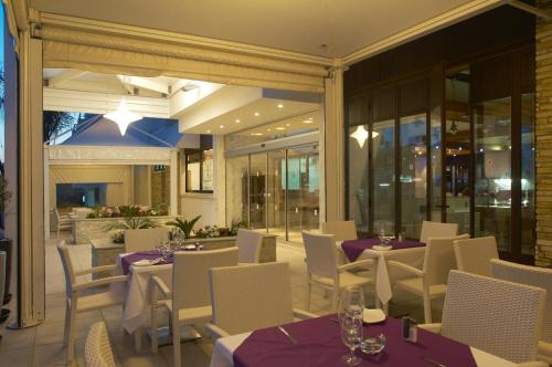 a restaurant with tables and chairs with purple table cloth at Senator Hotel Apartments - Adults Only in Ayia Napa