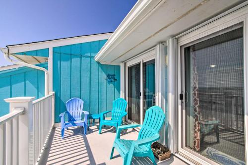 a porch with three blue chairs on it at Kure Beach Condo with Panoramic Ocean Views! in Kure Beach