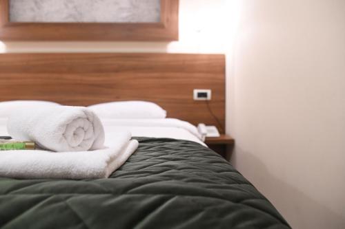 a bed with two towels on top of it at Hotel Garden in Novi Sad