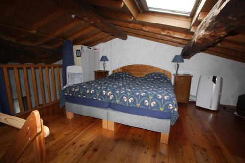 um quarto com uma cama e piso em madeira em Touroulet em Suze