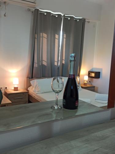 a bottle of wine and a wine glass on a table at VillaPouliezos Apartments in Alikanas