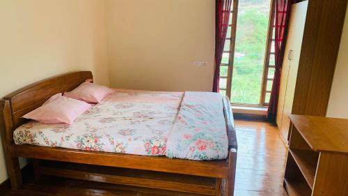 1 dormitorio con 1 cama de madera y 2 almohadas en Kee2 Wood House en Kodaikānāl