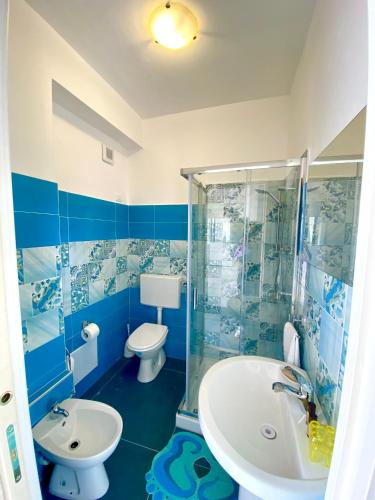 a blue and white bathroom with a toilet and a sink at Sperlonga Paradise Suites 500m dal mare in estate Servizio navetta per Sperlonga centro in Sperlonga