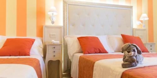un osito de peluche sentado en una cama en un dormitorio en Hotel Missouri en Bellaria-Igea Marina