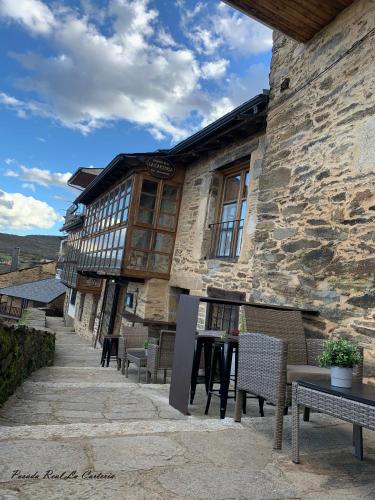 プエブラ・デ・サナブリアにあるPosada Real La Carteriaの目の前にテーブルと椅子が置かれた建物