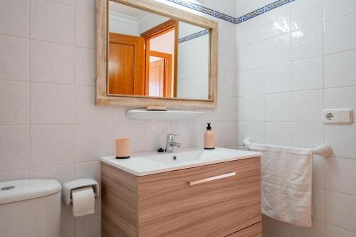ein Badezimmer mit einem Waschbecken, einem Spiegel und einem WC in der Unterkunft Apartamentos Karin 2°E in Felanitx