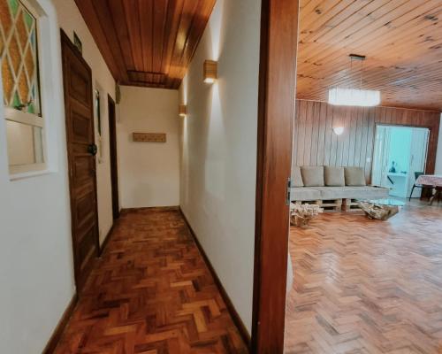 a hallway with a wooden ceiling and a room with a couch at Casa Wald in Campos do Jordão