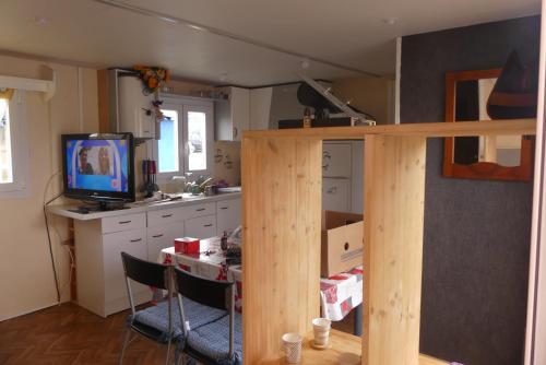 a kitchen with a table and a tv in a room at mobil-hom mag in Saillagouse