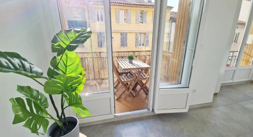 Cette chambre dispose d'un balcon avec une table et une plante. dans l'établissement MaxBnb - T2 Balcon 50m2 - Climatisé - Ouest -, à Toulon
