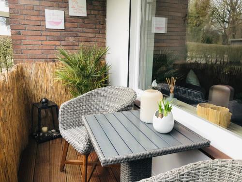 a patio with a table and chairs on a porch at Stranddistel Scharbeutz in Scharbeutz