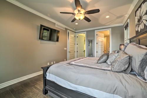 a bedroom with a bed with a ceiling fan at Luxe Waterfront Home with Private Lake Access! in West Branch